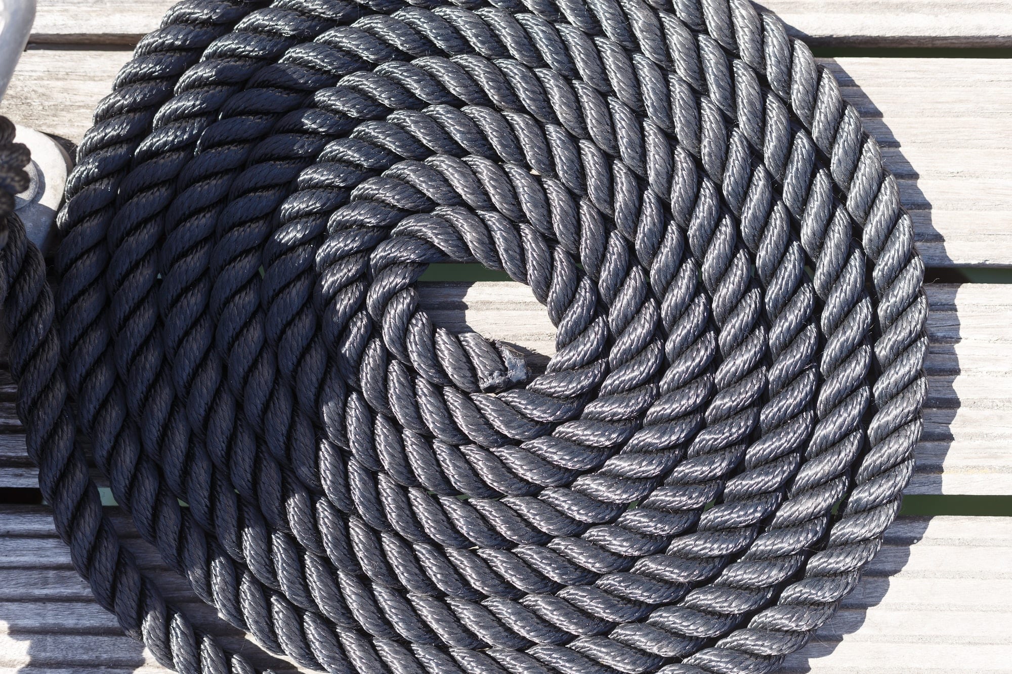 Close-up of a mooring rope on a wooden pier/ Nautical mooring ro